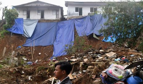 Warga melintas lokasi tanah longsor di Gang Barjo, Kelurahan Kebon Kalapa, Kota Bogor, Jawa Barat, Rabu (19/10/2022). Pemerintah Kota Bogor berencana merelokasi sebanyak 139 warga yang terdampak tanah longsor di Kelurahan Kebon Kalapa ke tempat yang lebih aman dari bencana longsor. 