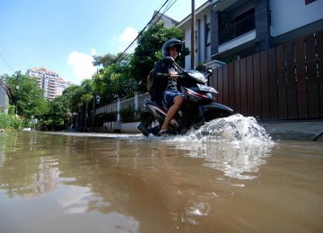 Warga melintas saat banjir yang melanda kawasan Petogogan, Jakarta Selatan, Minggu (12/2). (Republika/Prayogi)