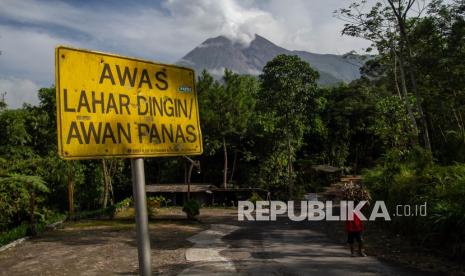 Warga melintas usai mencari rumput di Bukit Klangon, Glagaharjo, Cangkringan, Sleman, DI Yogyakarta, Ahad (13/3/2022). Berdasarkan rekomendasi Balai Penyelidikan dan Pengembangan Teknologi Kebencanaan Geologi (BPPTKG), Pemerintah Kabupaten Sleman menutup sementara sejumlah destinasi wisata yang berada dalam radius lima kilometer dari puncak Gunung Merapi pasca awan panas guguran pada Rabu (9/3).