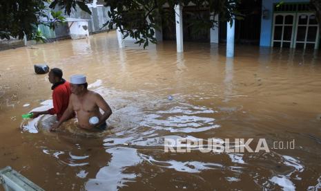 Warga melintasi banjir di Desa Pondok Joyo, Semboro, Jember, Jawa Timur, Kamis (11/11/2021). Menurut Badan Penanggulangan Bencana Daerah (BPBD) Jember sebanyak 1.294 rumah rumah warga terdampak banjir dan tanah longsor di tiga kecamatan di Jember yakni Semboro, Tanggul, dan Sumberbaru akibat hujan deras dan meluapnya air sungai sejak Rabu (10/11/2021). 