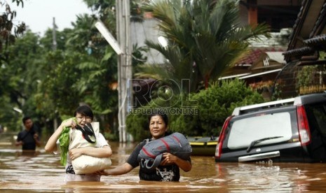   Warga melintasi banjir di Perumahan Bumi Nasio Indah, Jatiasih, Bekasi, Jawa Barat, Kamis (18/4).  (Republika/Adhi Wicaksono)