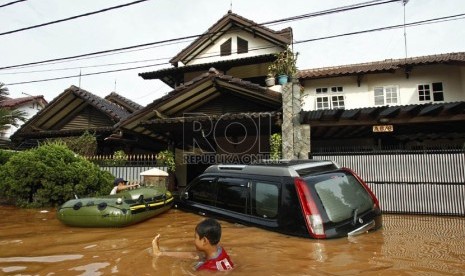  Warga melintasi banjir di Perumahan Bumi Nasio Indah, Jatiasih, Bekasi, Jawa Barat, Kamis (18/4). (Republika/Adhi Wicaksono)