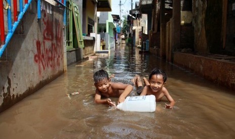 Warga melintasi banjir kiriman saat melanda kawasan Kampung Pulo, Jakarta Timur, Selasa (5/8). (Republika/ Yasin Habibi).