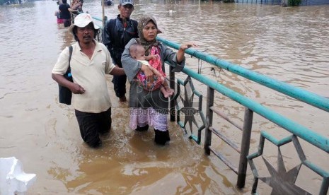   Warga melintasi banjir yang menggenangi Jalan Abdullah Syafei, Tebet, Jakarta Selatan, Rabu (16/1).(Republika/Aditya Pradana Putra)