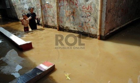  Warga melintasi banjir yang menggenangi kawasan Kampung Melayu Kecil 1, Poncol, Bukit Duri, Jakarta Selatan,Senin (22/10).   (Agung Fatma Putra)