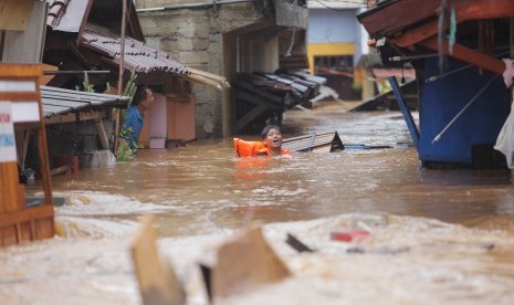 Warga melintasi banjir yang menggenangi Perumahan kawasan Jalan H. Ipin, Pondok Labu, Jakarta, Rabu (1/1/2020). Tingginya intensitas hujan sejak membuat jalan H.Ipin ke Pondok Labu terputus, Rabu (1/2). Segera ganti pakaian basah akibat banjir agar terhindar penyakit hipotermia..  