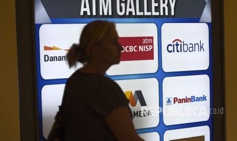 Warga melintasi galeri anjungan tunai mandiri (ATM) 