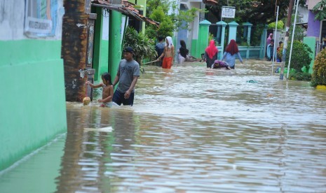 Warga melintasi gang yang digenangi banjir (ilustrasi)