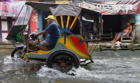 Warga melintasi genangan air akibat banjir rob di Bagan Deli, Belawan, Kota Medan (ilustrasi) 