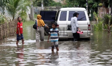  Warga melintasi genangan air saat banjir melanda perumahan Ciledug indah 1, Ciledug, Tangerang, Banten, Kamis (16/1).     (Republika/Yasin Habibi)