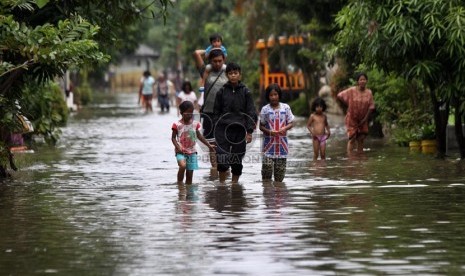  Warga melintasi genangan air saat banjir melanda perumahan Ciledug indah 1, Ciledug, Tangerang, Banten, Kamis (16/1).     (Republika/Yasin Habibi)