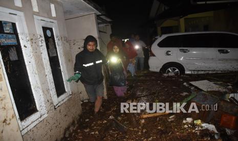 Warga melintasi genangan banjir bandang di Desa Mekarsari, Kecamatan Cicurug, Kabupaten Sukabumi, Jawa Barat, Senin (21/9/2020). Pada pukul 20.30, Pusat Pengendali Operasi (Pusdalops) BNPB mencatat sebanyak 12 rumah hanyut, 85 rumah terendam dan 1 unit mobil tersapu saat banjir bandang.