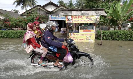 Warga melintasi genangan banjir menggunakan kendaraan roda dua di Desa Kawunganten, Cilacap, Jateng, Sabtu (8/10/2022). Curah hujan tinggi selama beberapa hari terakhir menyebabkan sejumlah wilayah di Kabupaten Banyumas, Cilacap, Kebumen mengalami bencana banjir dan longsor yang menyebabkan satu orang meninggal akibat tertimpa longsor.