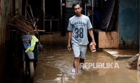 Warga melintasi genangan ketika banjir menggenangi kawasan permukiman di Jakarta Timur, pekan lalu. (ilustrasi)