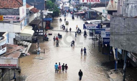 Warga melintasi jalan yang terkena banjir di kawasan Pantura, Pamanukan, Subang, Jabar, Rabu (22/1). 