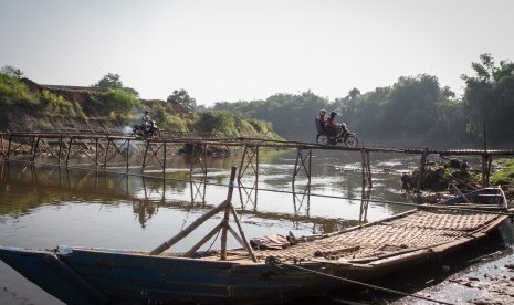 Warga melintasi jembatan bambu di atas Sungai Bengawan Solo yang menghubungkan Desa Mojolaban, Sukoharjo dengan Kampung Sewu di Solo, Jawa Tengah, Rabu (19/6/2019).