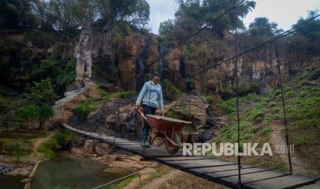 Warga melintasi Jembatan Gantung Cisanggarung, Cimenyan, Kabupaten Bandung, Jawa Barat