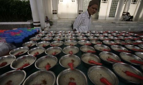  Warga melintasi makanan tradisional Aceh Kanji Rumbi di Masjid Raya Baiturrahman di Banda Aceh, Rabu (17/7).  (EPA/Hotli Simanjuntak)