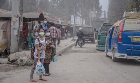 Warga memakai masker untuk mengantisipasi terhirup debu vulkanik erupsi Gunung Sinabung, di Brastagi, Karo, Sumatra Utara.