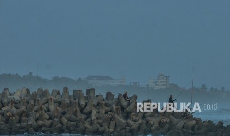 Warga memancing ikan di atas beton pemecah ombak di Pantai Barat, Kampung Pananjung, Kabupaten Pangandaran, Jawa Barat, Senin (2/9/2019).