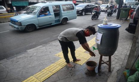 Warga memanfaatkan fasilitas cuci tangan yang disediakan oleh pemilik toko atau tempat usaha di Kawasan Jalan Jatinegara Barat, Jakarta.