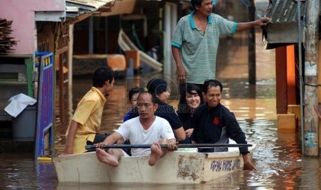  Warga memanfaatkan perahu kecil untuk melintasi genangan air banjir di Kawasan Jatinegara,Jakarta Timur, Rabu (13/2).  (Republika/Prayogi)