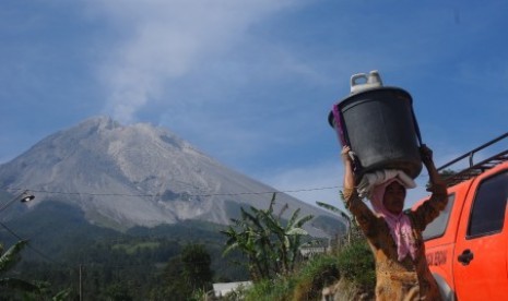 Warga memanggul ember berisi air di Stabelan, Tlogolele, Selo, Boyolali, Jawa Tengah, Sabtu (2/6). Warga lereng Gunung Merapi yang sempat mengungsi, kembali menjalani aktivitas pagi mereka pascaletusan Gunung Merapi pada Jumat (1/6). 