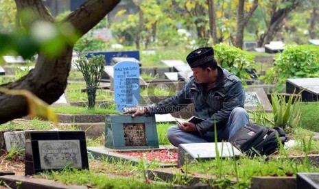  Warga memanjatkan doa ketika berziarah ke makam salah satu keluarganya di TPU Karet, Jakarta,Selasa (2/7).  (Republika/Agung Supriyanto)