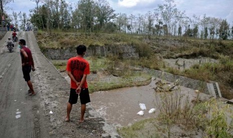  Warga memantau aliran lahar dingin Gunung Kelud yang melintasi Kecamatan Puncu, Kediri, Jawa Timur, Selasa (18/2). (Republika/Adhi Wicaksono)