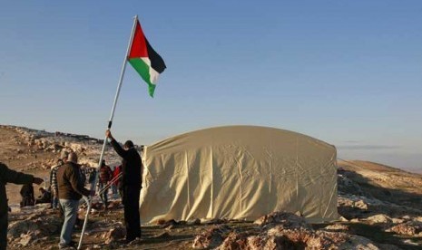 Warga memasang bendera Palestina dekat kota Jerusalem.