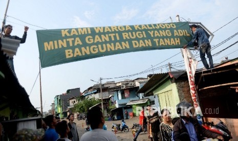  Warga memasang spanduk yang bertuliskan tuntutan ganti rugi atas penertiban permukiman di Kalijodo, Jakarta, Kamis (18/2).