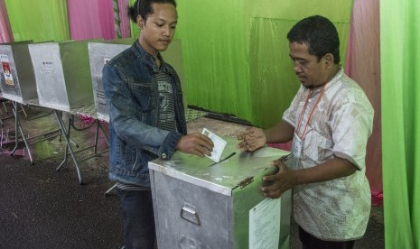 Warga memasukkan surat suara ke dalam kotak suara saat pemilihan ulang Pilkada DKI Jakarta di TPS 01 Utan Panjang, Kemayoran, Jakarta, Minggu (19/2). 