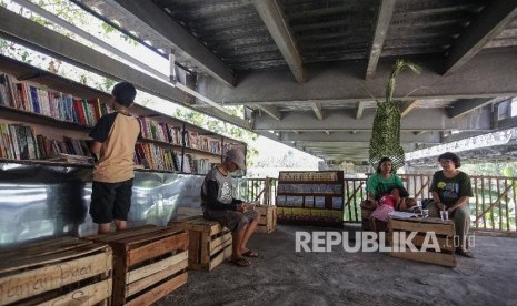 Warga membaca buku di Jembatan Edukasi, kolong jembatan Siluk, Imogiri, Bantul, DI Yogyakarta. 