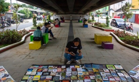 Warga membaca buku di perpustakaan jalanan di Taman Millenial, Karawang, Jawa Barat, Rabu (8/5/2019). 