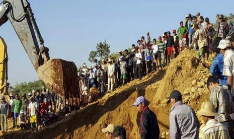 Warga membantu mencari korban longsor di area penambangan giok Hpa Kant jade mining, Kachin State, utara Myanmar, Ahad (22/11). 