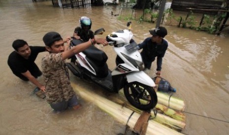 Warga membantu mengevakuasi sepeda motor guna melewati banjir di Desa Cot Girek Kandang, Muara Dua, Lhokseumawe, Aceh, Jumat (1/12). Banjir yang disebabkan tingginya intensitas hujan mengguyur provinsi Aceh sejak sepekan mengakibatkan sejumlah kabupaten/kota barat dan timur Aceh mulai teredam banjir. 