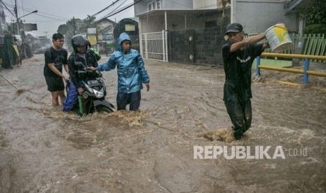 Warga membantu pengendara yang terjebak banjir di kawasan Cikutra, Bandung, Jawa Barat, Kamis (22/11/2018).