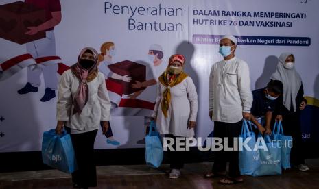 Warga membawa bantuan sembako COVID-19 di Kantor bank bjb, Bandung, Jawa Barat, Senin (16/8/2021). Bank bjb terus berupaya mendukung pemerintah Indonesia dengan memberikan bantuan sembako bagi masyarakat terdampak COVID-19 yang diantaranya yatim, dhuafa, veteran, petugas kebersihan, loper koran yang tersebar di Bandung Raya, Jabodetabek, DKI, Ciayumajakuning, Priangan, Banten pada momen HUT Ke-76 RI. 