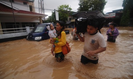  Warga membawa barang miliknya melintasi banjir ketika akan mengungsi ke tempat yang lebih aman di Wenang, Manado, Sulawesi Utara, Rabu (15/1).  (Antara/Fiqman Sunandar)