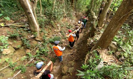 Warga membawa bibit bambu yang akan ditanam di hulu Sungai kawasan Perhutani di Papring, Kalipuro, Banyuwangi, Jawa Timur.