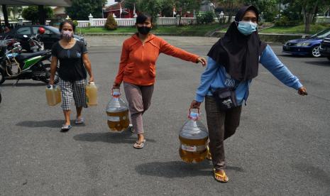 Warga membawa minyak goreng curah yang dibeli saat Operasi Pasar Minyak Goreng Curah di Gedung Serbaguna Pemkab Sleman, D.I Yogyakarta, Kamis (28/4/2022). Pemerintah melarang ekspor minyak goreng untuk mengatasi kenaikan harga minyak goreng di dalam negeri.