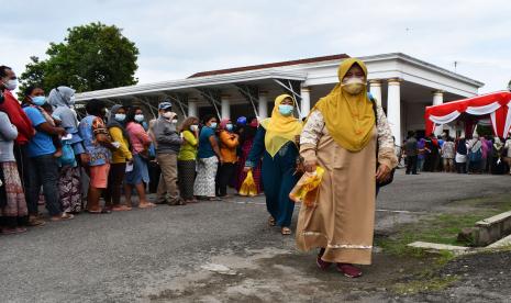 Warga membawa minyak goreng yang dibeli saat operasi pasar minyak goreng di halaman pendapa Bakorwil Madiun, Jawa Timur, Selasa (15/2/2022). Operasi Pasar Minyak Goreng Murah bersama Gubernur Jawa Timur Khofifah Indar Parawansa tersebut menyediakan sekitar tiga ribu liter minyak goreng kemasan yang dijual dengan harga Rp12.500 per liter dan setiap pemilik KTP mendapat jatah dua liter. 