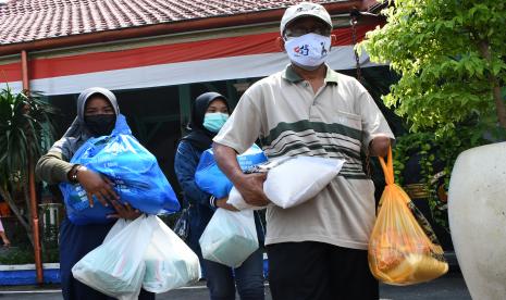 Warga membawa paket bantuan bahan pokok seusai penyerahan bantuan sosial di Pendopo Muda Graha, Kabupaten Madiun, Jawa Timur, Senin (2/8/2021). Pemkab Madiun membagikan bantuan sosial bahan pokok kepada 810 anak yatim piatu, 525 orang penyandang disabilitas, 60 orang eks penyandang psikotik dan 100 orang lanjut usia guna meringankan beban saat pandemi COVID-19.