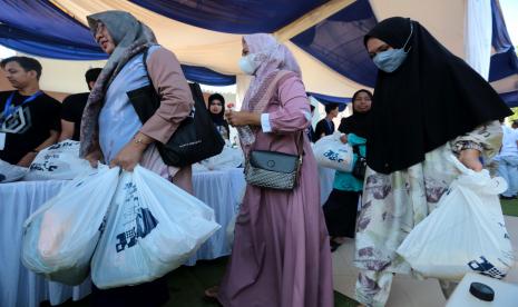 Warga membawa paket sembako dari pasar rakyat dan bazar UMKM BUMN.  PT Pupuk Indonesia (Persero) menyalurkan 1.000 paket sembako sekaligus membuka bazar UMKM yang diselenggarakan di Gor Karias Amuntai, Hulu Sungai Utara, Kalimantan Selatan (Kalsel).