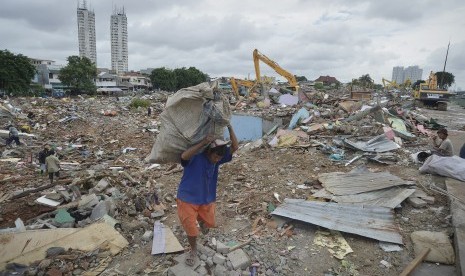 Warga membawa sisa-sisa besi di antara bangunan yang dirobohkan di kawasan Kalijodo, Jakarta, Selasa (1/3).