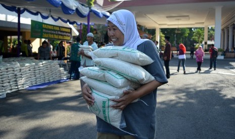 Warga membawa zakat fitrah berupa beras. 