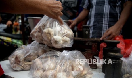 Warga membeli bawang putih saat dilaksanakananya operasi pasar komoditas bawang putih di Pasar Senen, Jakarta, Kamis (1/6). 