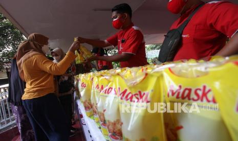 Warga membeli minyak goreng saat digelarnya pasar minyak goreng murah di Kantor Kelurahan Jemur Wonosari, Surabaya, Jawa Timur, Jumat (21/1/2022). Minyak goreng murah yang dijual dengan harga Rp14.000 per liter itu bisa dibeli warga setempat dengan menunjukkan KTP serta kupon khusus sehingga mampu meringankan beban ekonomi masyarakat 