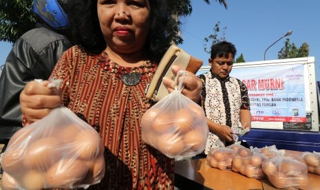 Warga membeli telur ayam murah saat operasi pasar yang diselenggarakan Tim Pengendali Inflasi Daerah (TPID) di Kota Kediri, Jawa Timur, Selasa (24/7).