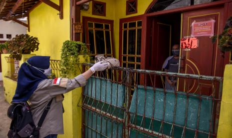 Warga memberikan paket makanan untuk warga yang sedang menjalani isolasi mandiri di rumahnya di Jalan Gunung Batu, Sukaraja, Kota Bandung.